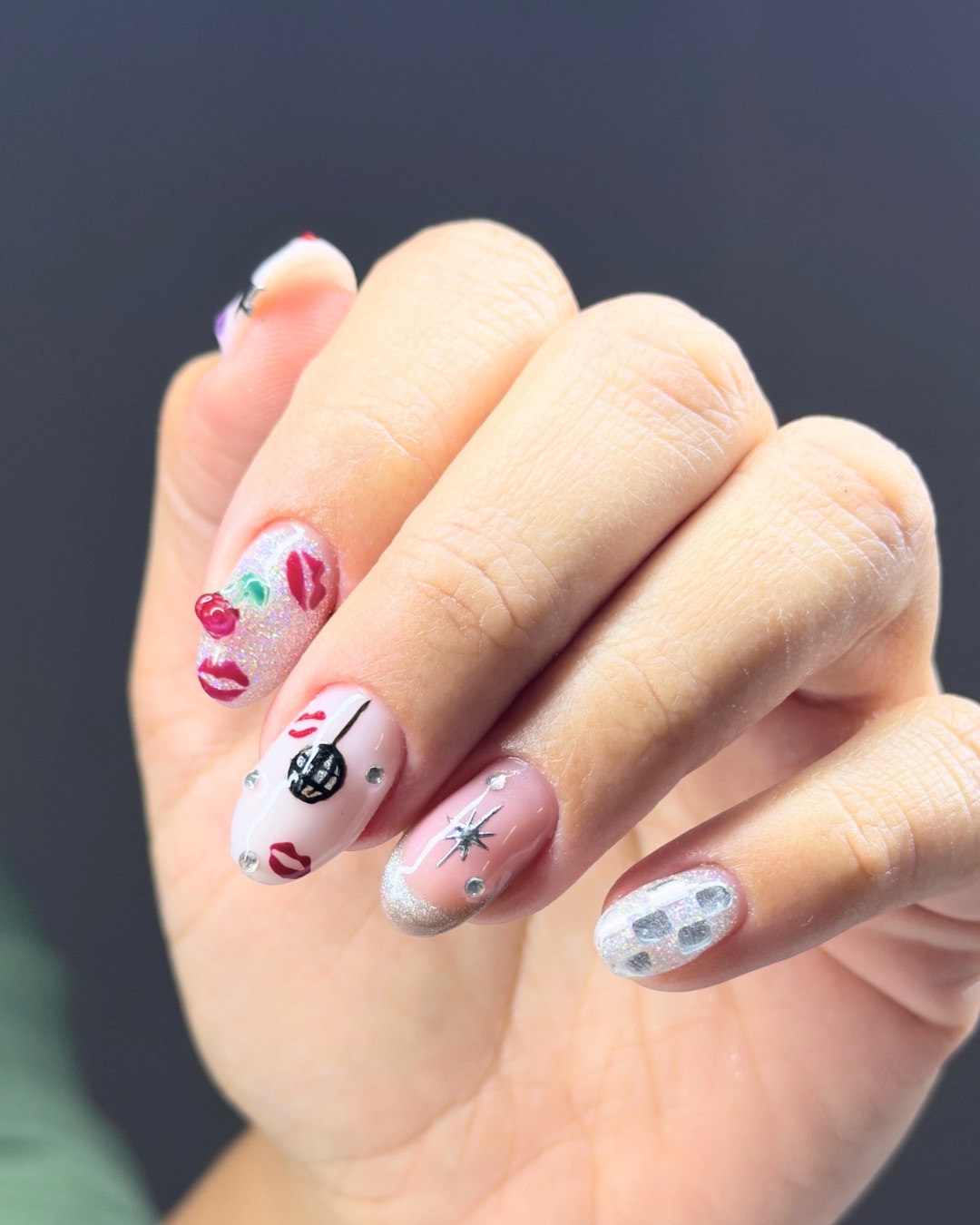 Unhas rosa com desenhos de lábios e glitter